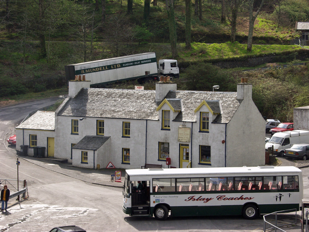 Picture of a coach with Islay Coaches written on the side outside of a harbour building