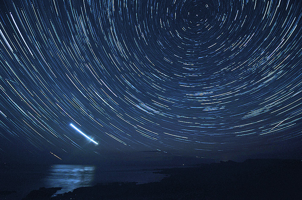 Picture of star trails around the north stay over a bay