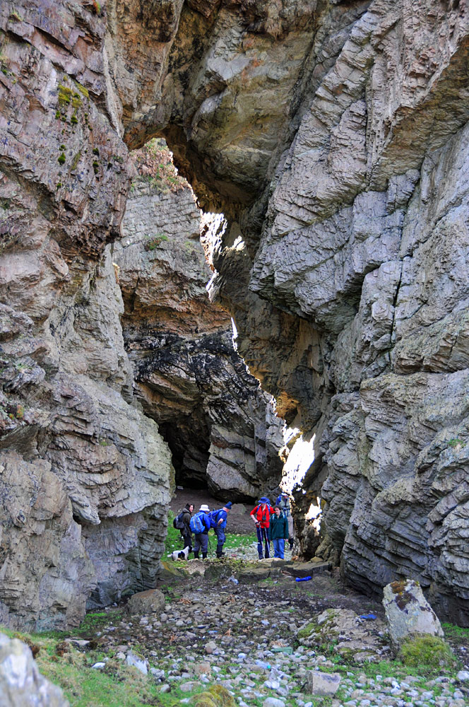 Picture of a group of walkers standing below a natural arch