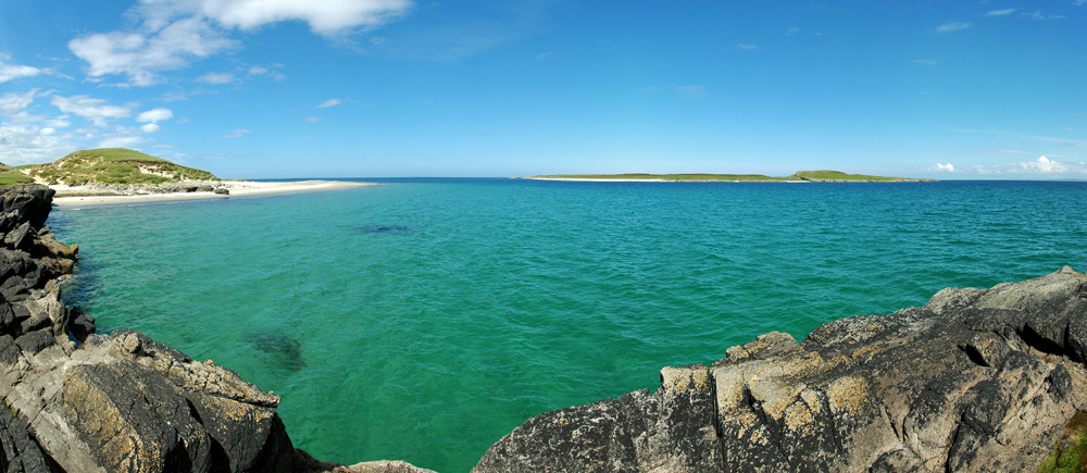 Picture of a panoramic view from the tip of an island, looking out to another island