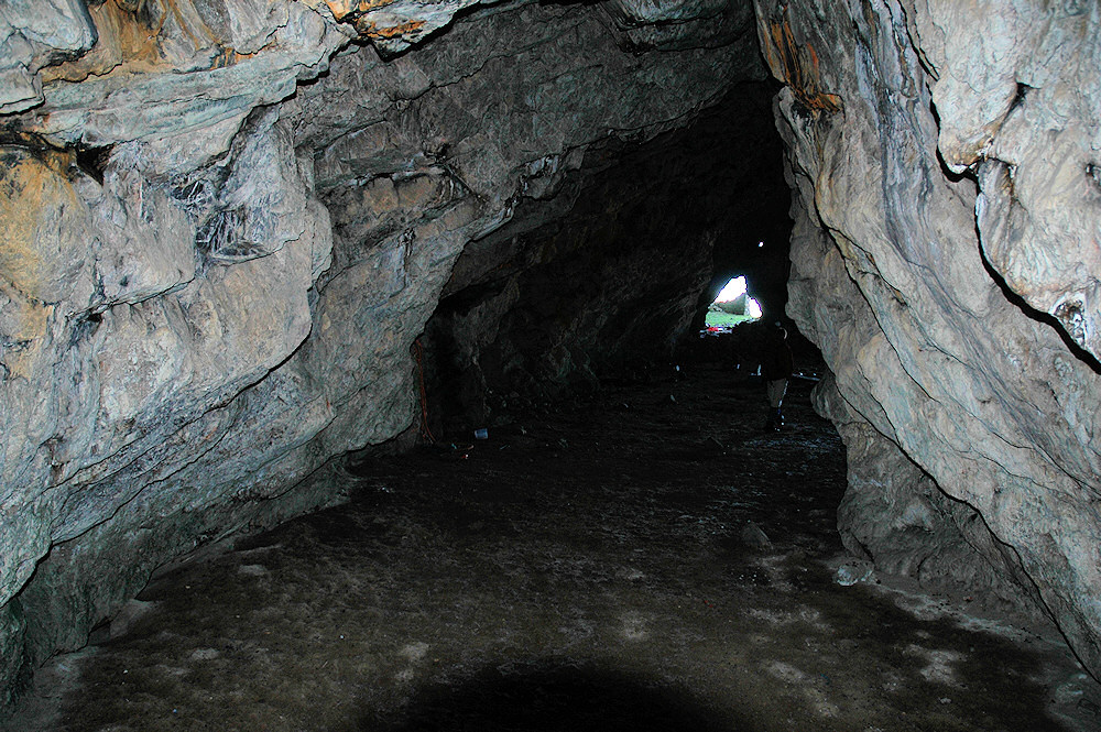 Picture of a view inside of a cave, the exit visible in the distance