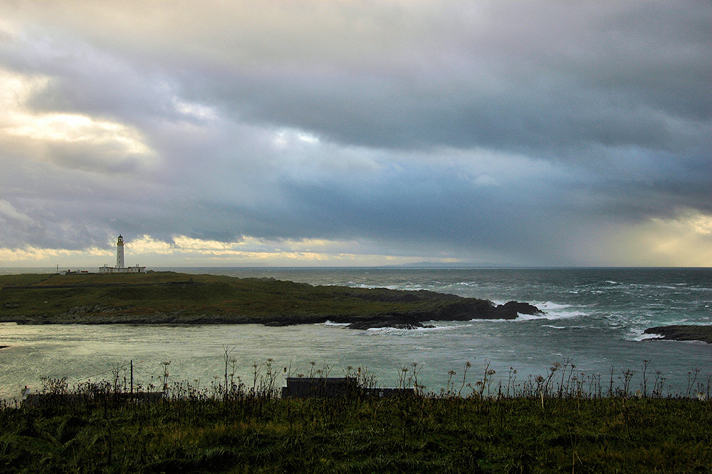 Picture of a view to a lighthouse on a small island on a cloudy windy day