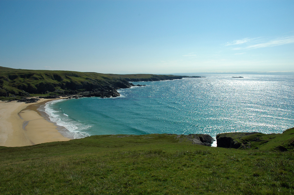 Picture of bay with a sandy beach in a lush green coastline