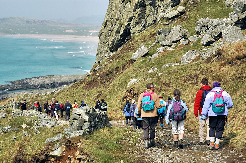 Picture of a group of walkers on a track above a bay