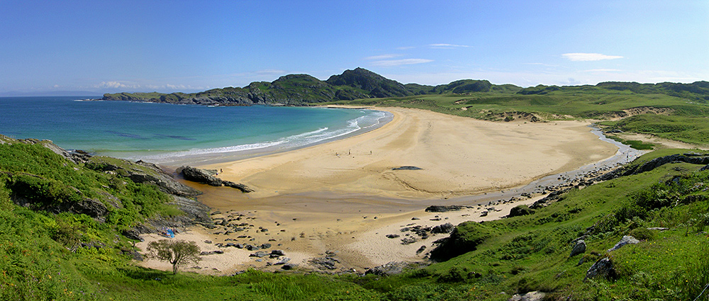 Panoramic picture of a view over a bay with a golden sandy beach