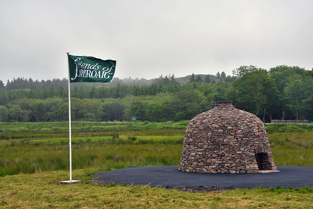 Picture of a dry stone cairn with a Friends of Laphroaig flag next to it