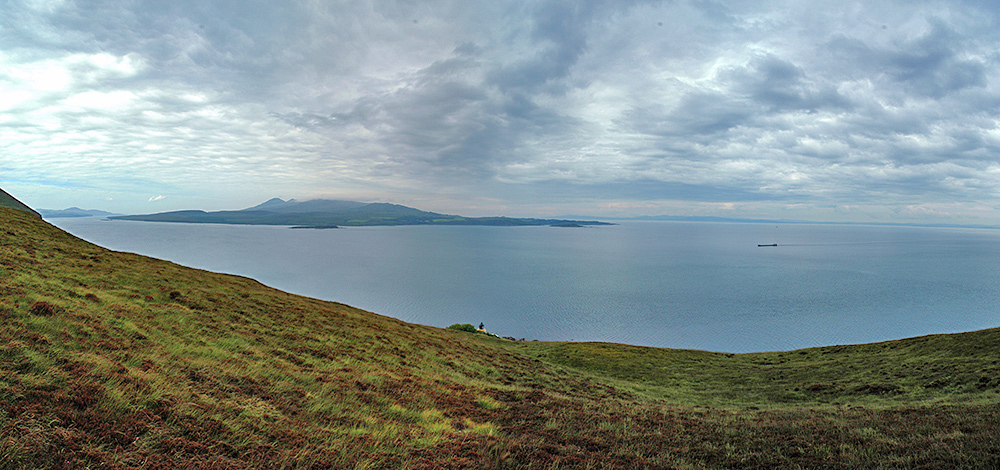 Panoramic picture of the entrance to a sound between two islands, a lighthouse just visible below
