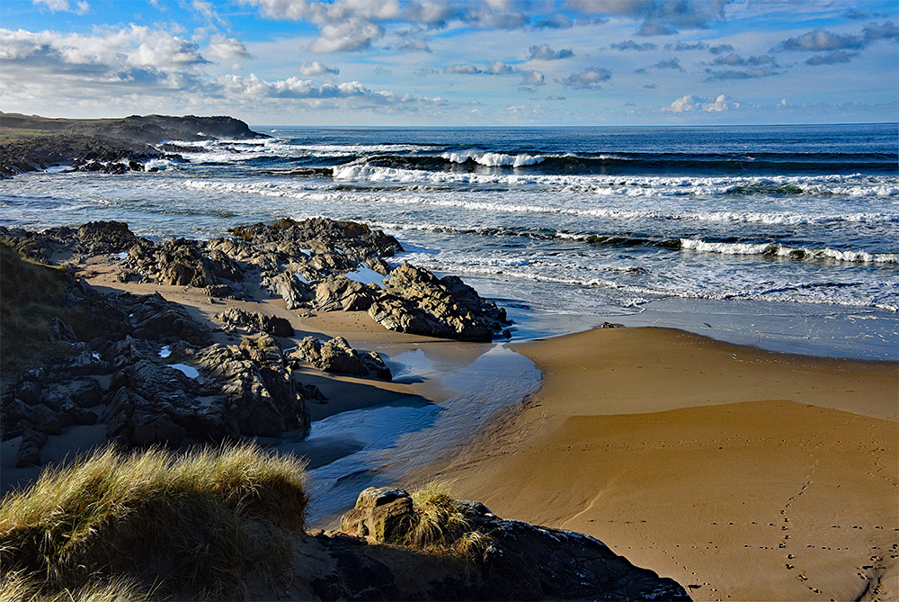 Picture of a view from dunes on to a beach on a bright sunny day