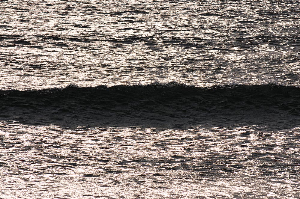 Picture of a small wave throwing a shadow from some low sun