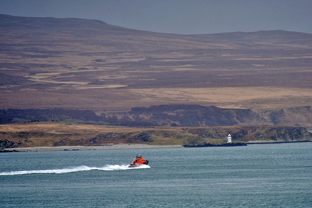 Picture of an RNLI lifeboat passing a small lighthouse