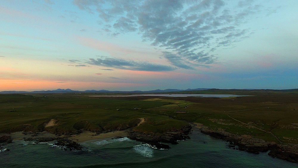 Picture of a bay with a beach and a freshwater loch in the last light of the gloaming