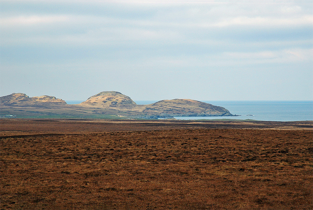 Picture of some cliffs and a bay seen of heathery moorland