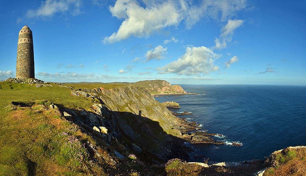 Panoramic picture of a monument on the top of steep cliffs on a sunny June evening
