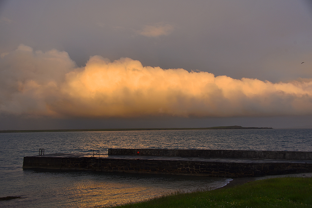 Picture of a bank of clouds in the evening light over a peninsula