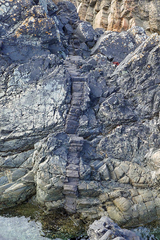 Picture of a rock formation looking like tiny steps on a rocky shore