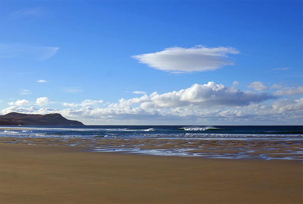 Picture of a lenticular cloud over a bay with a sandy beach
