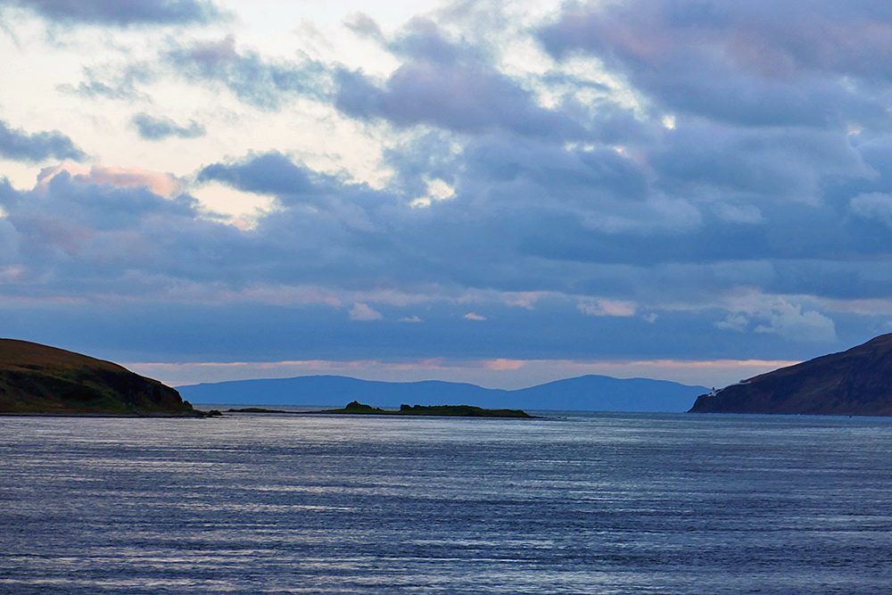 Picture of a view down a sound between two Islands, a lighthouse in the distance