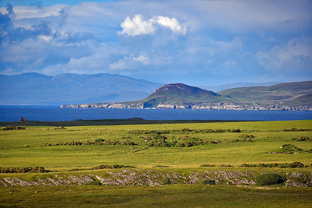 Picture of a small round hill seen from the distance across land and sea