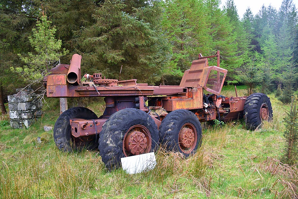 Picture of an old rusty machine/vehicle abandoned in woods