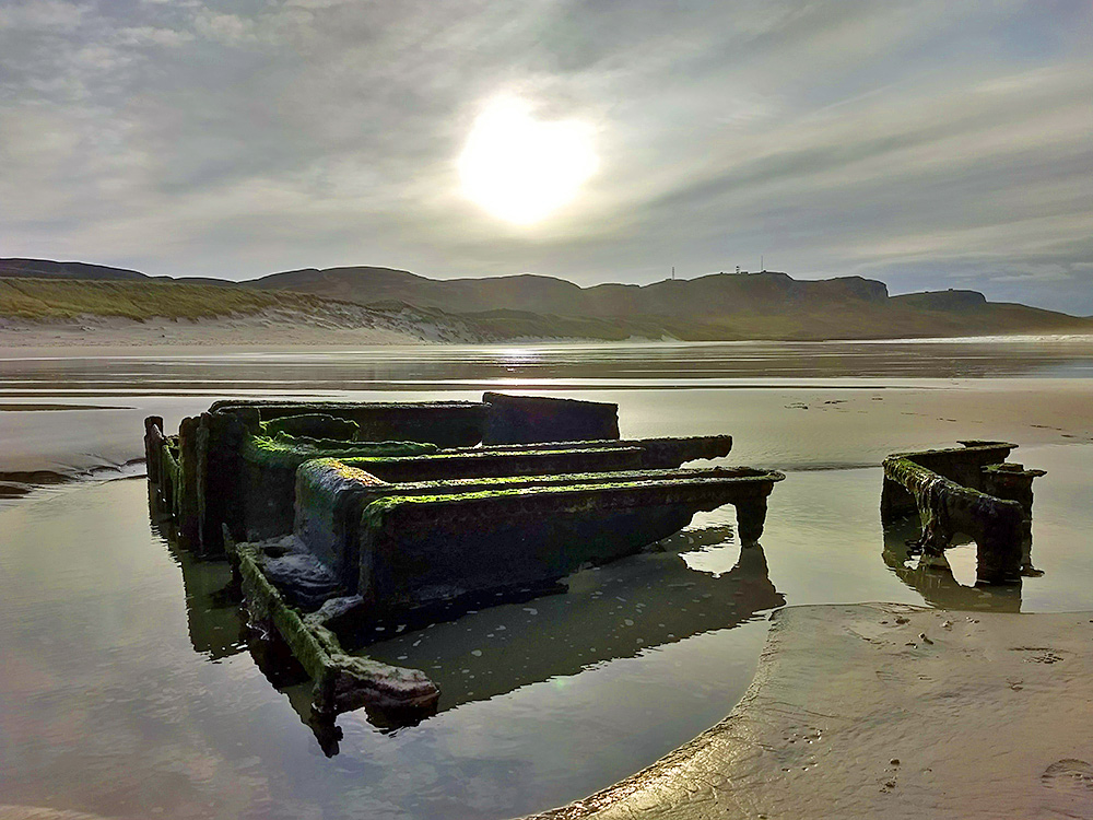 Picture of a wreck on a beach in hazy sunshine
