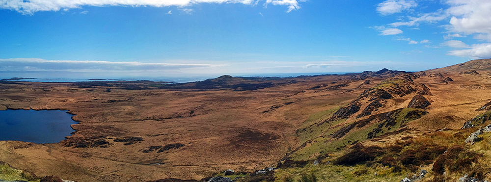 Panoramic picture of a coastal landscape with low hills in brilliant sunshine