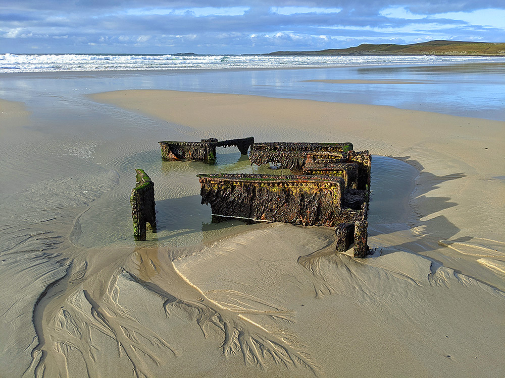 Picture of a wreck in a sandy beach in the morning sun
