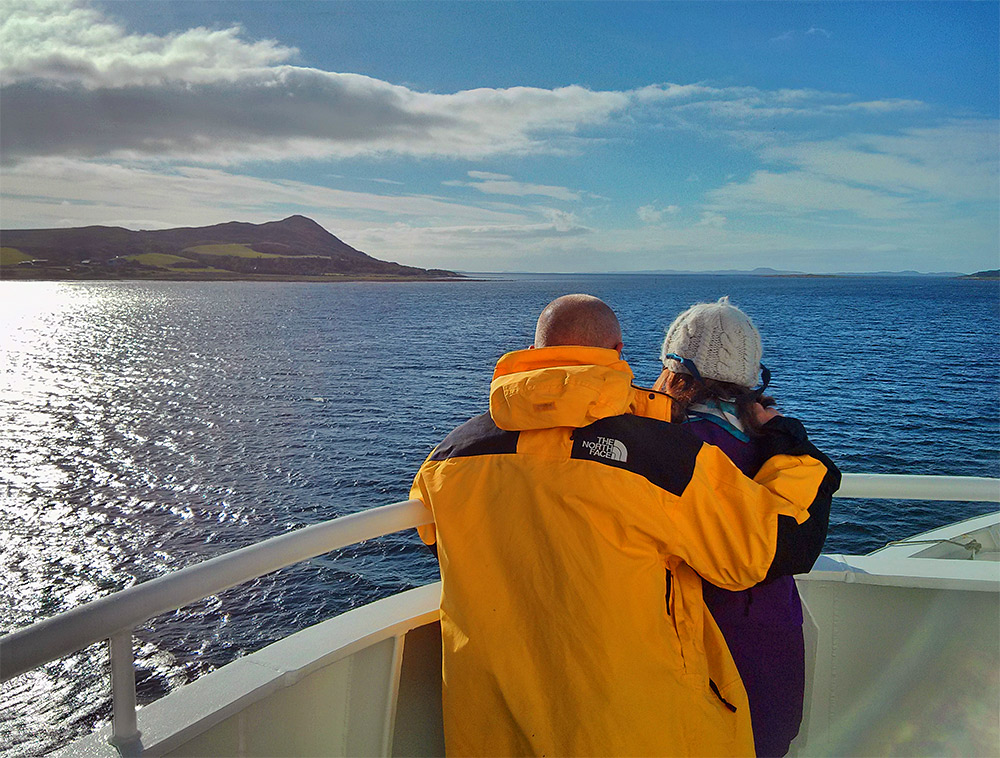 Picture of a couple standing near the bow of a ferry leaving a loch