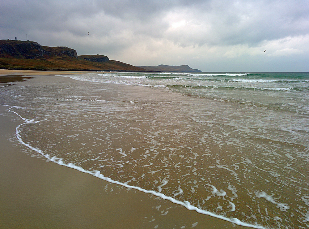 Picture of a cloudy beach scene with waves rolling in