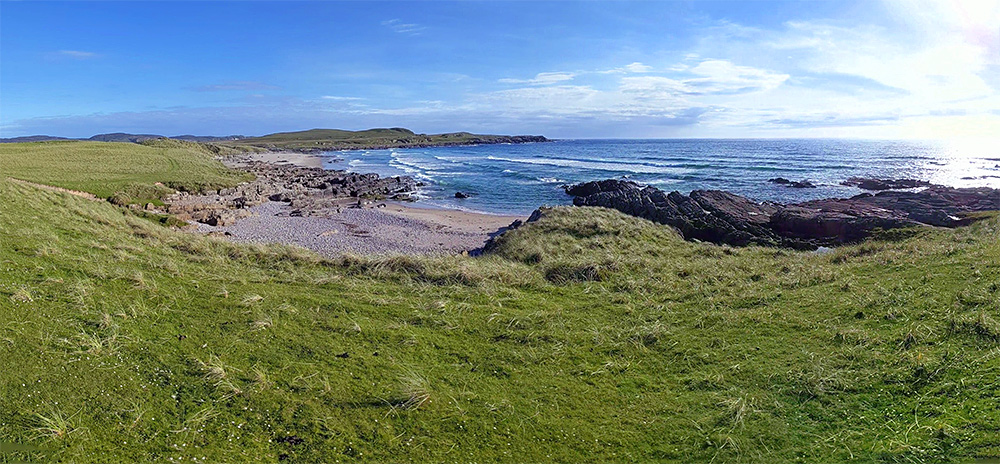 Panoramic picture of a bay with a sandy beach, also a rocky beach