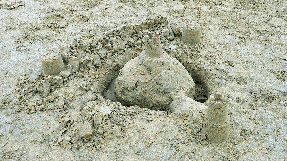 Picture of a sandcastle with a moat on a beach