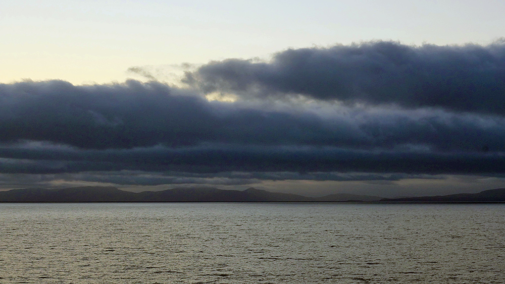 Picture of some low clouds over two islands seen from an approaching ferry