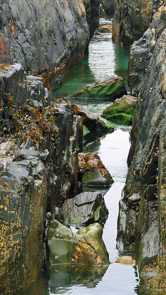 Picture of a water filled rock channel between some cliffs