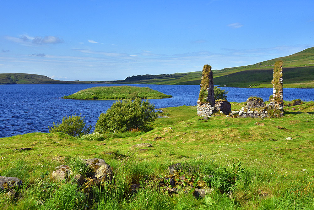 Picture of a small island off a larger island in a loch, a ruin on the larger island