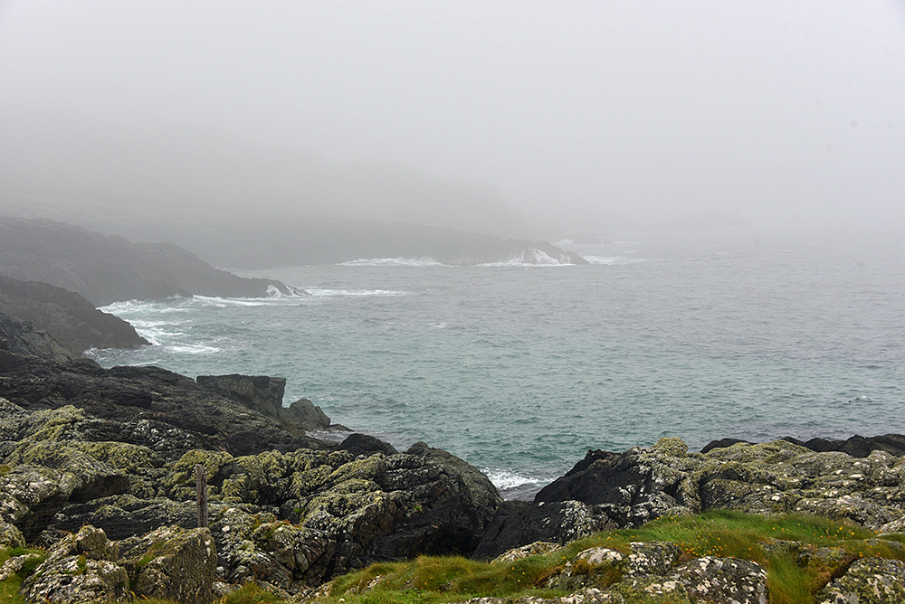 Picture of a row of coastal cliffs disappearing into the fog