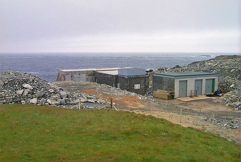 Picture of some low buildings on a rocky shoreline, housing an experimental wave power station