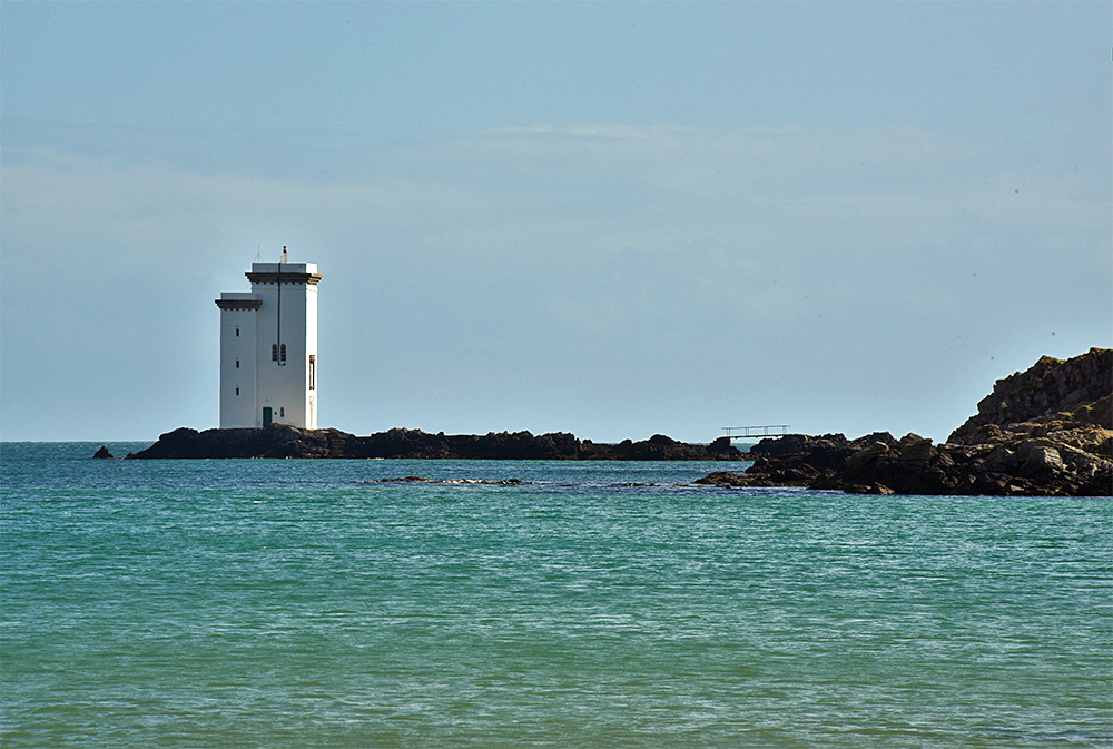 Picture of a square lighthouse on a rocky outcrop