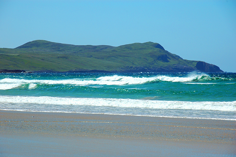 Picture of breaking waves in a wide bay on a bright June day