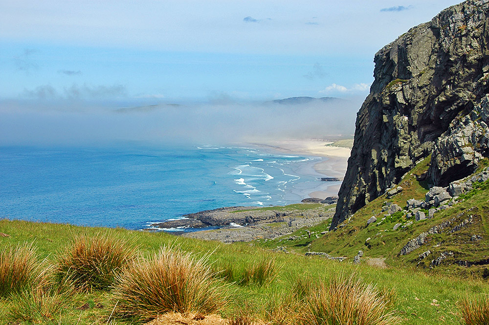 Picture of low fog (locally known as haar) over a bay with a beach below some cliffs