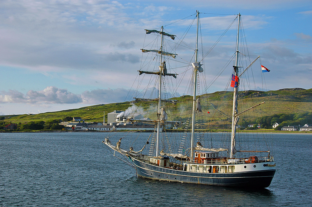 Picture of a tall ship anchored off a distillery and maltings