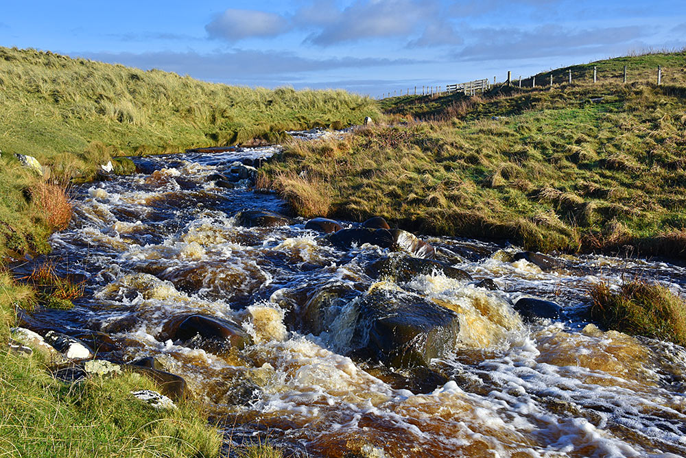 Picture of a small river in full flow over some rocks