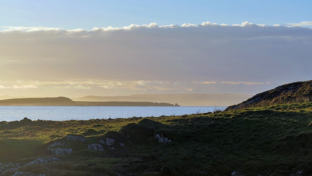 Picture of a coastal view across a sea loch at sunrise, a point and a peninsula in the distance
