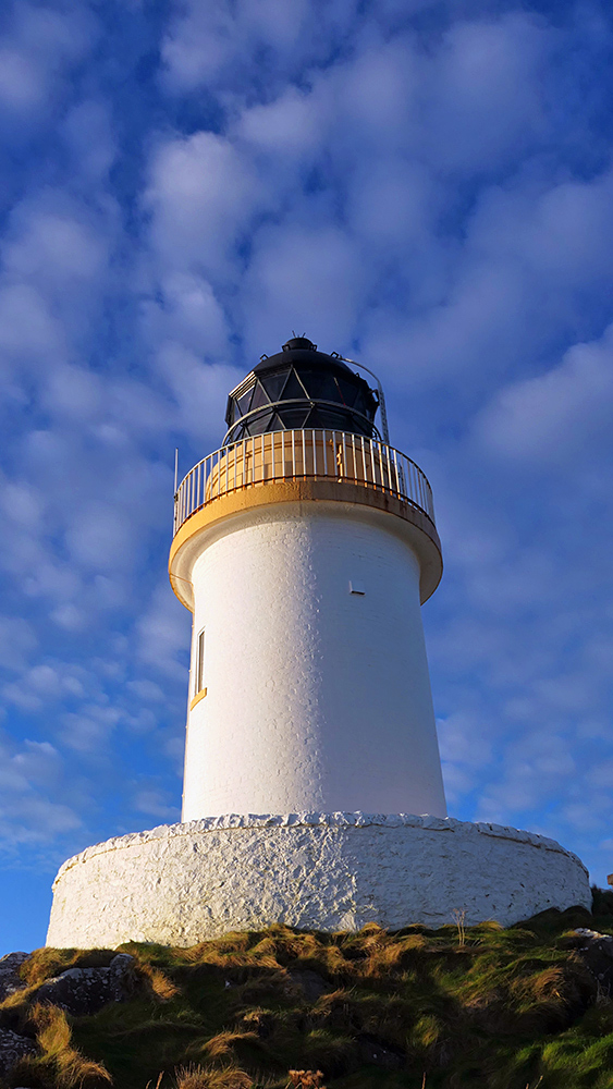 Picture of a small round whitewashed lighthouse
