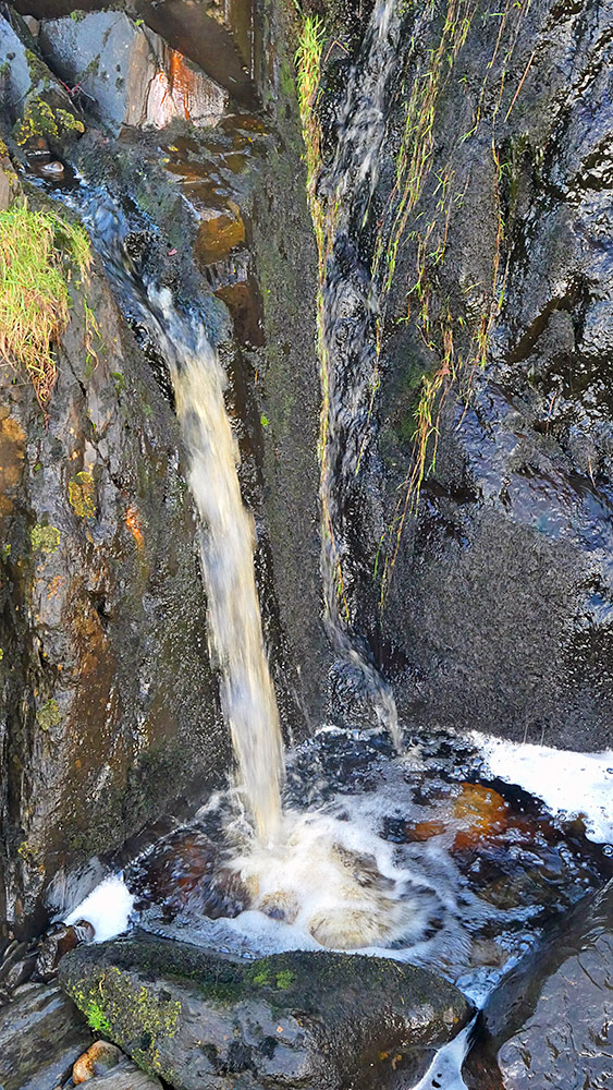 Picture of the last step of a small waterfall, falling into a small rock basin