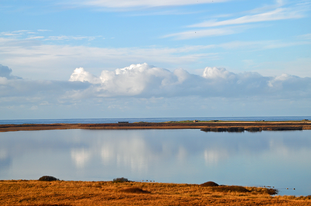 Picture of a calm freshwater loch on a November afternoon, the Atlantic in the background