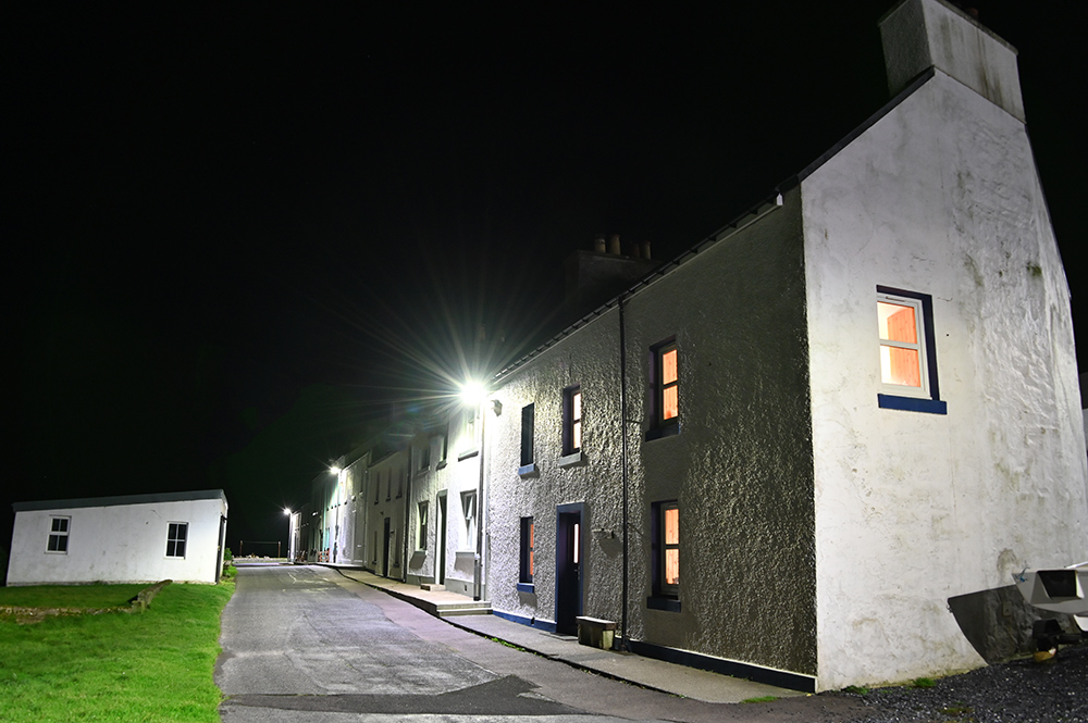 Picture of a row of whitewashed cottages in a coastal village at night