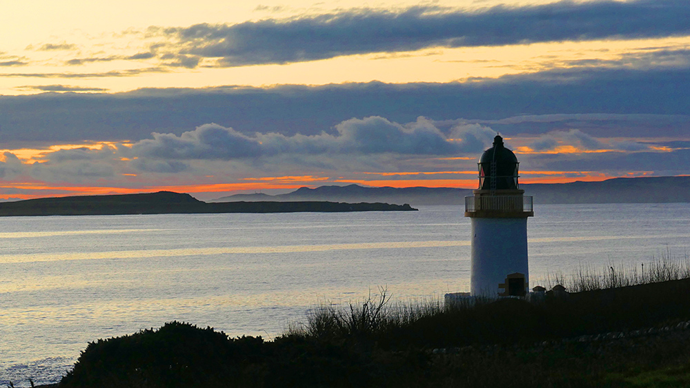 Picture of a small lighthouse on the shore of a sea loch during a November dawn