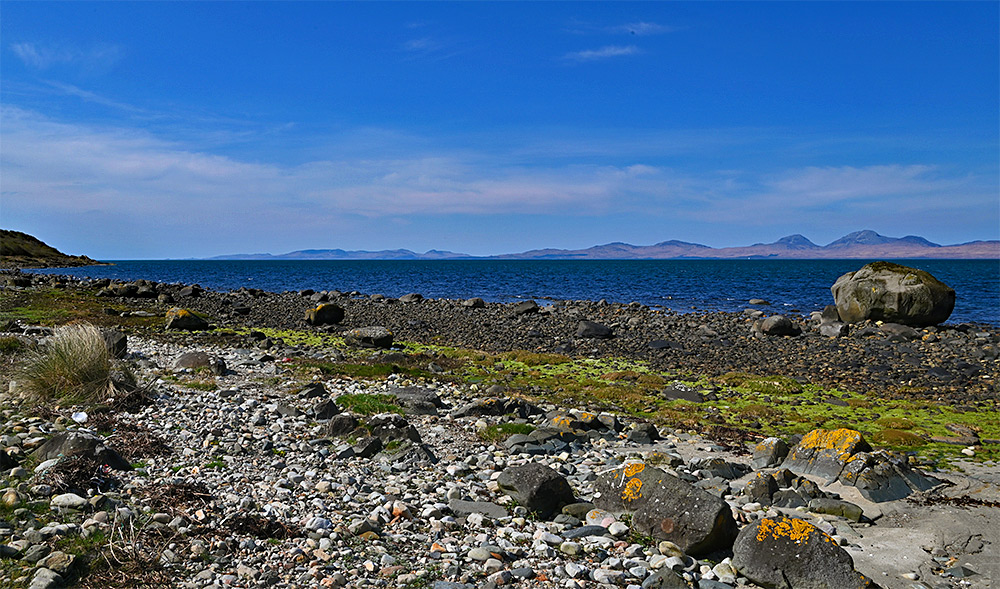Picture of a view across a sound between the mainland and two islands, a huge boulder on the shore