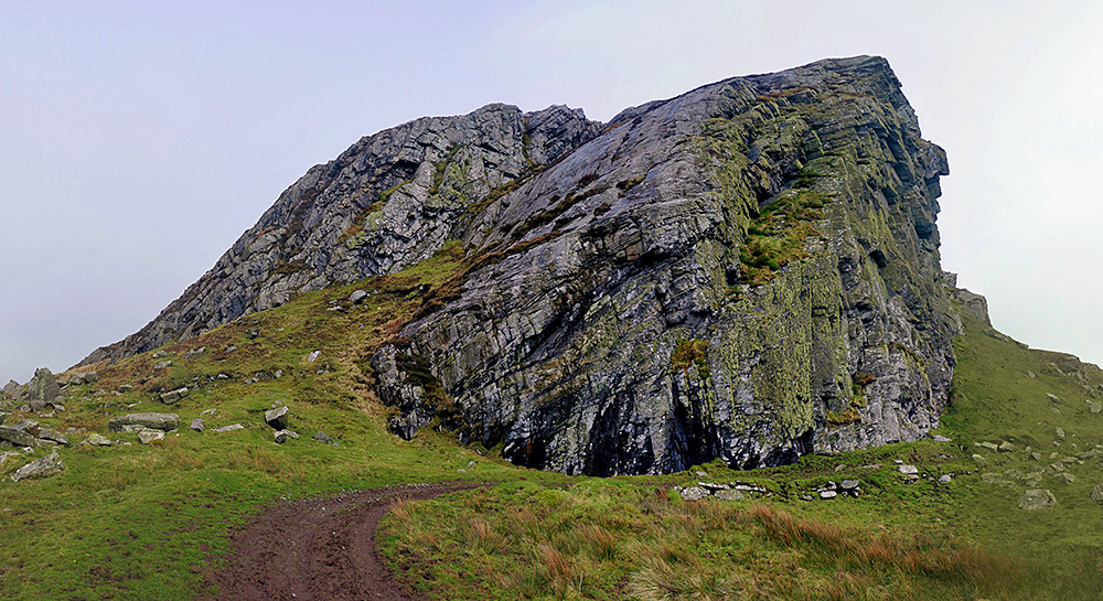Picture of some steep crags with a rock formation on the side resembling and old woman