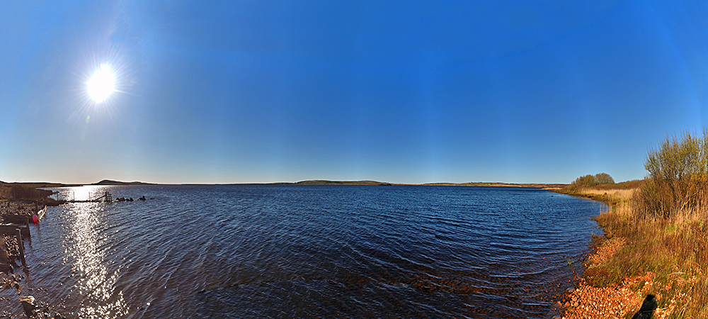 Panoramic picture of a freshwater loch on a bright sunny day