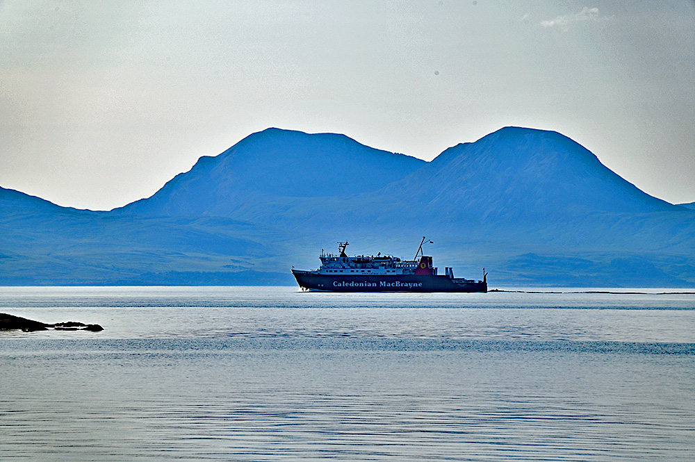 Picture of the Calmac ferry MV Lord of the Isles with the hazy Paps of Jura in the background
